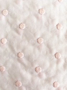 Tela blanca con topos rosa grandes