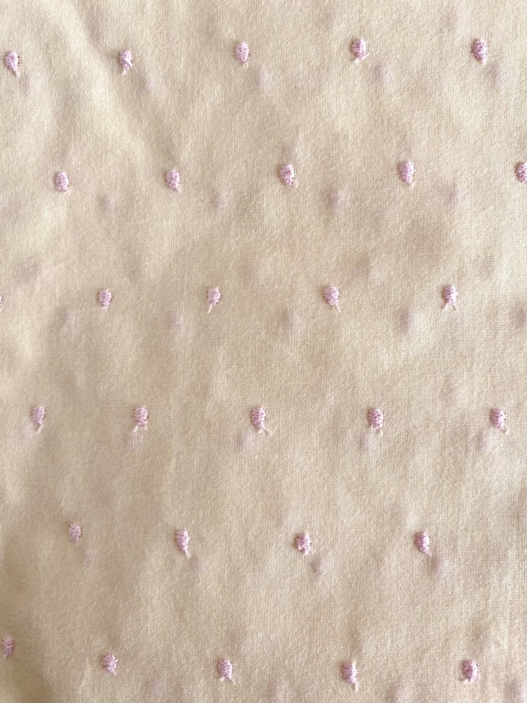 Tela amarilla con topos rosa